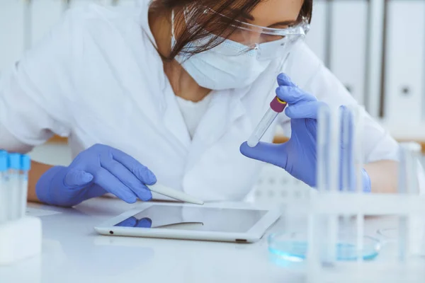 Close-up de cientista profissional feminino em óculos de proteção fazendo experiência com reagentes em laboratório. Medicina e conceito de pesquisa — Fotografia de Stock