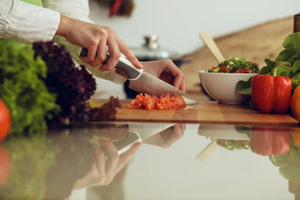 Manos humanas desconocidas cocinando en la cocina. Mujer cortando tomates rojos. Comida saludable y concepto de comida vegetariana —  Fotos de Stock