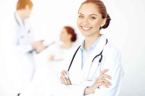 Alegre mujer-médico sonriente en el fondo de su paciente en la cama. Concepto de medicina — Foto de Stock