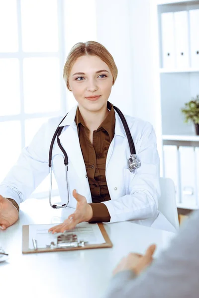 Young woman doctor and patient at medical examination in hospital office. Khaki colored blouse of therapist looks good. Medicine, healthcare and doctors appointment concept — Stock Photo, Image