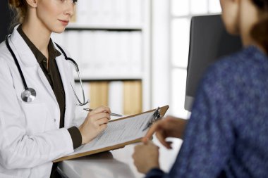 Doktor ve hasta klinikte otururken sağlık muayenesini tartışıyorlar. Hastanede mükemmel bir tıbbi hizmet. Tıp konsepti