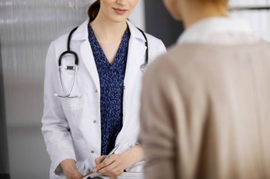 Doktor ve hasta klinikte otururken sağlık muayenesini tartışıyorlar. Hastanede mükemmel bir tıbbi hizmet. Tıp konsepti