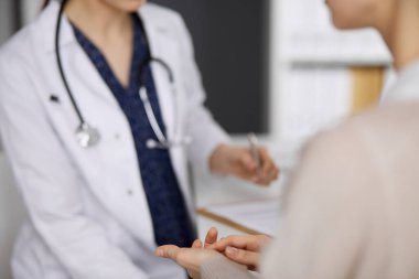 Doktor ve hasta klinikte otururken sağlık muayenesini tartışıyorlar. Hastanede mükemmel bir tıbbi hizmet. Tıp konsepti