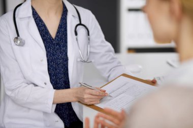 Doktor ve hasta klinikte otururken sağlık muayenesini tartışıyorlar. Hastanede mükemmel bir tıbbi hizmet. Tıp konsepti