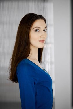 Dost canlısı Asyalı öğrenci kız dik duruyor. İş vesikalığı ya da ofiste portre