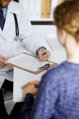 Kadın doktor ve erkek hasta klinikte otururken sağlık muayenesini tartışıyorlar. Tıp konsepti