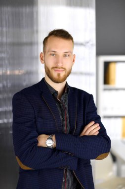 Kızıl sakallı, dost canlısı yetişkin iş adamı kameraya bakıyor. İş vesikalığı ya da ofiste portre