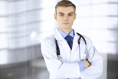 Steteskoplu bir doktor hastane ofisinde duruyor. Klinikte mükemmel bir tıbbi hizmet. Tıp ve sağlık sektöründe mutlu bir gelecek