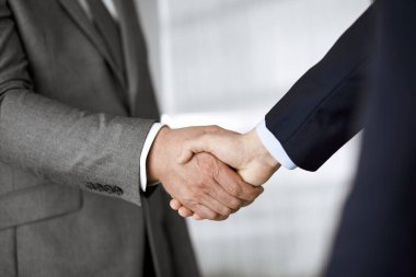 Ofisteki iş adamları ayakta ve el sıkışıyorlar, yakın plan. İş iletişimi kavramı. El sıkışma ve pazarlama