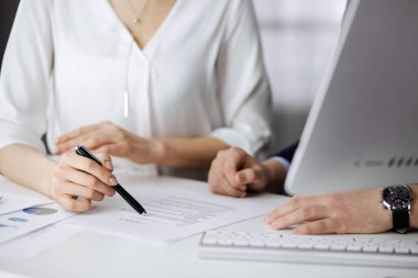 Bilinmeyen iş adamı ve kadın ofiste sözleşmeyi tartışıyorlar. Yakın çekim. İş adamları ya da avukatlar toplantıda birlikte çalışıyorlar. Takım çalışması ve ortaklık