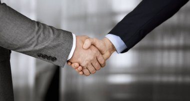 Ofisteki iş adamları ayakta ve el sıkışıyorlar, yakın plan. İş iletişimi kavramı. El sıkışma ve pazarlama