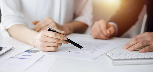 Bilinmeyen işadamı ve kadın güneşli ofiste sözleşmeyi tartışıyorlar, yakın plan. İş adamları veya avukatlar toplantıda birlikte çalışıyorlar.