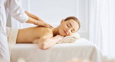Güzel bir kadın kapalı gözlerle sırt masajından hoşlanıyor. Spa tedavisi kavramı