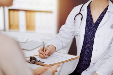 Doktor ve hasta güneşli klinikte otururken sağlık muayenesini tartışıyorlar. Hastanede mükemmel bir tıbbi hizmet.