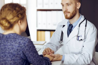 Dost canlısı kızıl sakallı doktor, kadın hastasına güven veriyor. Tıp etiği ve güven kavramı, tıp teması