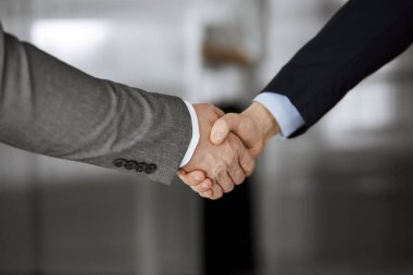 Ofisteki iş adamları ayakta ve el sıkışıyorlar, yakın plan. İş iletişimi kavramı. El sıkışma ve pazarlama