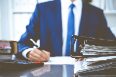 Dosyalarda işadamı ya da muhasebeci tarafından işleme konmayı bekleyen dosyalar var. Muhasebe bütçesi. Denetim, sigorta ve iş konsepti