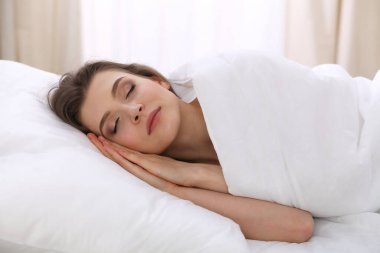Yatağında yatarken uyuyan güzel bir genç kadın. Aktif yaşam için keyifli ve dinlenme kavramı