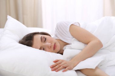Yatağında yatarken uyuyan güzel bir genç kadın. Aktif yaşam için keyifli ve dinlenme kavramı