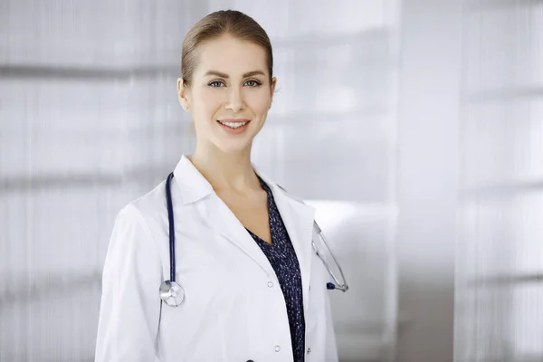 Allegro dottore donna in piedi in clinica. Ritratto di amichevole sorridente medico donna. Servizio medico perfetto in ospedale. Concetto di medicina — Foto Stock