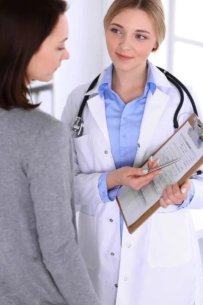 Young woman doctor and patient at medical examination at hospital office. Blue color blouse of therapist looks good. Medicine and healthcare concept — Stock Photo, Image