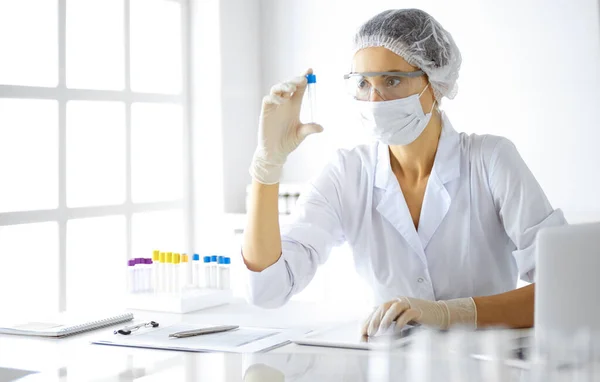 Científica profesional en gafas protectoras investigando tubo con reactivos en laboratorio. Conceptos de medicina e investigación — Foto de Stock