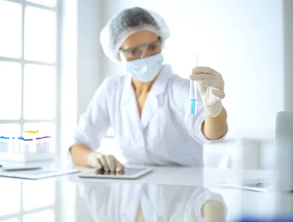 Cientista profissional em óculos de proteção pesquisando tubo com reagentes em laboratório. Conceitos de medicina e pesquisa — Fotografia de Stock