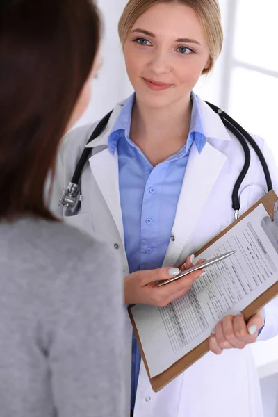 Junge Ärztin und Patientin bei der ärztlichen Untersuchung im Krankenhaus. Blaue Bluse des Therapeuten sieht gut aus. Medizin und Gesundheitskonzept — Stockfoto