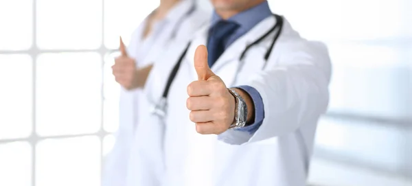 Egy csapat orvos mutogatja a hüvelykujját. Tökéletes orvosi ellátás a klinikán. Boldog jövőt az orvostudomány és az egészségügy területén — Stock Fotó