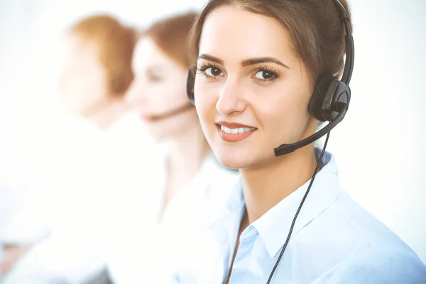 Operatori di call center. Concentrarsi sulla bella donna d'affari utilizzando cuffie Foto Stock Royalty Free