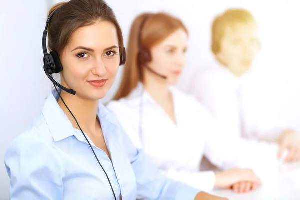 Centro de llamadas. Céntrate en la hermosa mujer de negocios usando auriculares en la oficina soleada Fotos de stock