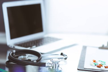 Stetoskop, cam masada dizüstü bilgisayarla duran reçeteli tıbbi form. İlaç ya da eczane konsepti. Doktor çalışma masasında tıbbi aletler