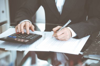 Muhasebeci kadın ya da mali müfettiş rapor hazırlıyor, hesaplıyor ya da dengeyi kontrol ediyor, yakın plan. İş, denetim veya vergi kavramları