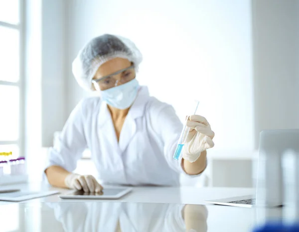 Professzionális női tudós védőszemüvegben, kémcsövet kutatva reagensekkel a laboratóriumban. Az orvostudomány és a kutatás fogalma — Stock Fotó