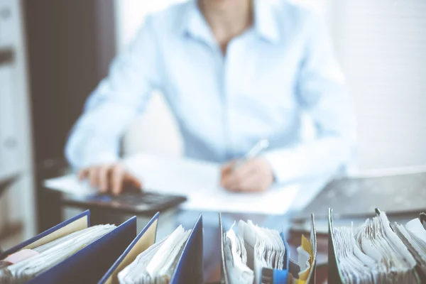 Encuadernaciones de papeles esperando a ser procesados por la contable mujer o inspector financiero, de cerca. Retrato de negocios. Conceptos de auditoría o impuestos — Foto de Stock