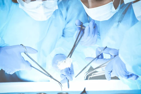 Primer plano del equipo médico que realiza la operación. Grupo de cirujanos en el trabajo están ocupados de pacientes. Medicina, veterinaria o sanitaria y emergencia en el hospital — Foto de Stock