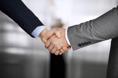 Ofisteki iş adamları ayakta ve el sıkışıyorlar, yakın plan. İş iletişimi kavramı. El sıkışma ve pazarlama