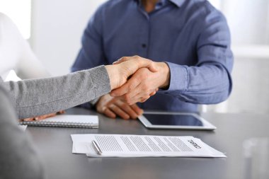Bir grup iş adamı modern ofiste soruları tartıştıktan sonra el sıkışıyor. El sıkışın, yakın plan. İş konseptinde takım çalışması, ortaklık ve anlaşma