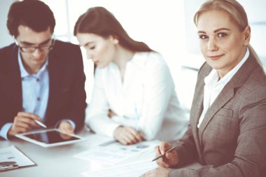 Pazarlıktaki iş kadınının vesikalığı. Bir grup iş adamı modern ofiste soruları tartışıyor. Takım çalışması, ortaklık ve iş konsepti