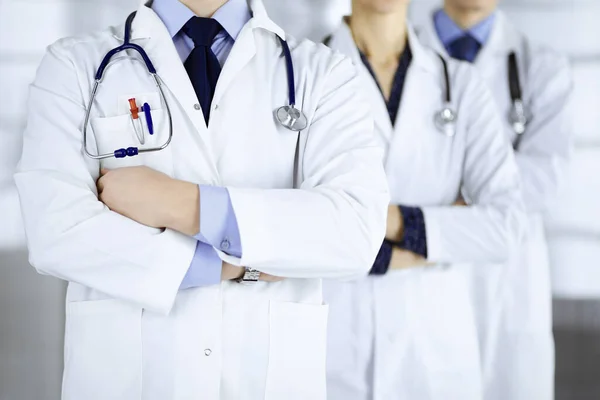 Moderne dokters staan als een team met gekruiste armen en stethoscopen in het ziekenhuiskantoor. Artsen klaar om patiënten te onderzoeken en te helpen. Medische hulp, verzekering in de gezondheidszorg, beste desease — Stockfoto