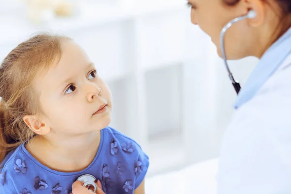 Doctor examining a little girl by stethoscope. Happy smiling child patient at usual medical inspection. Medicine and healthcare concepts — Stock Photo, Image