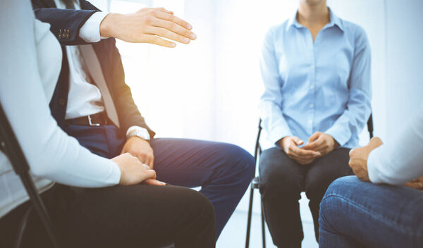 Группа людей, сидящих в кругу во время терапии в солнечном офисе. Встреча бизнес-команды, участвующей в тренинге