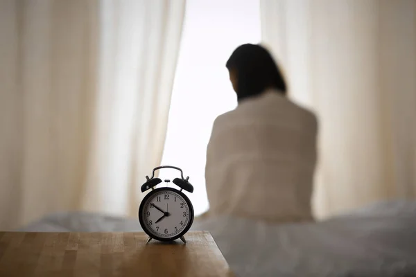 Femme étirant les mains au lit après le réveil, éruption de soleil. Brunette entrant dans une journée heureuse et détendue après une bonne nuit de sommeil et vue arrière. Concept d'une nouvelle journée et d'un week-end joyeux — Photo