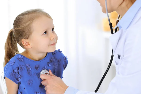 Medico che esamina una bambina dallo stetoscopio. Felice paziente bambino sorridente al solito controllo medico. Concetti di medicina e sanità — Foto Stock