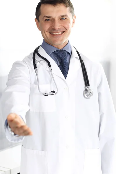 Doutor homem alegre sorrindo para a câmera, ajudando a mão. Serviço médico perfeito na clínica. Futuro feliz na medicina e na saúde — Fotografia de Stock