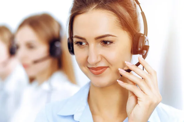 Τηλεφωνητές. Εστίαση στην όμορφη γυναίκα των επιχειρήσεων χρησιμοποιώντας ακουστικά σε ηλιόλουστο γραφείο — Φωτογραφία Αρχείου