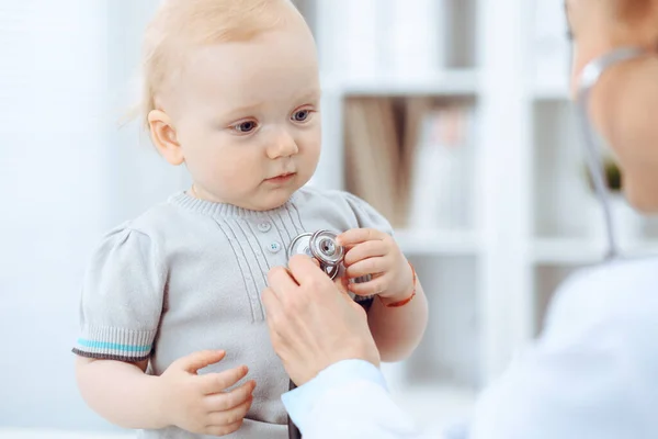 Arzt und Patient im Krankenhaus. Kleines Mädchen wird vom Arzt mit Stethoskop untersucht. Medizinkonzept — Stockfoto