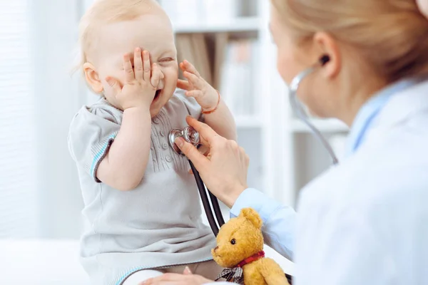 Médico y paciente en el hospital. La niña está siendo examinada por un médico con estetoscopio. Concepto de medicina — Foto de Stock