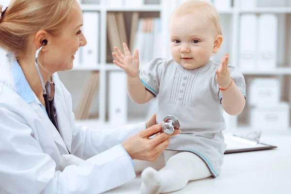 Läkare och patient på sjukhus. En liten flicka undersöks av läkare med stetoskop. Medicinskt koncept — Stockfoto