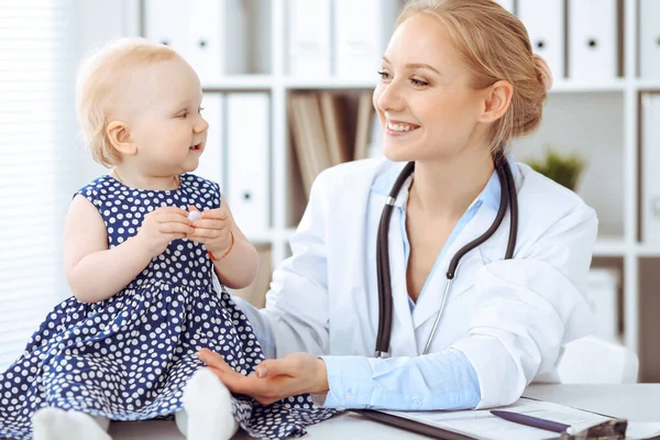 Médecin et patient à l'hôpital. Petite fille habillée en robe bleu foncé dans les pois est examiné par un médecin avec stéthoscope. Concept de médecine — Photo